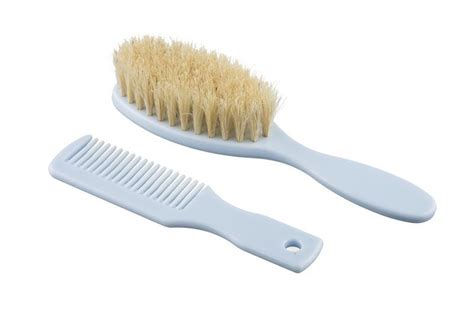 Fotografie a unui set de perie și pieptene pentru bebeluși, cu peri naturali.