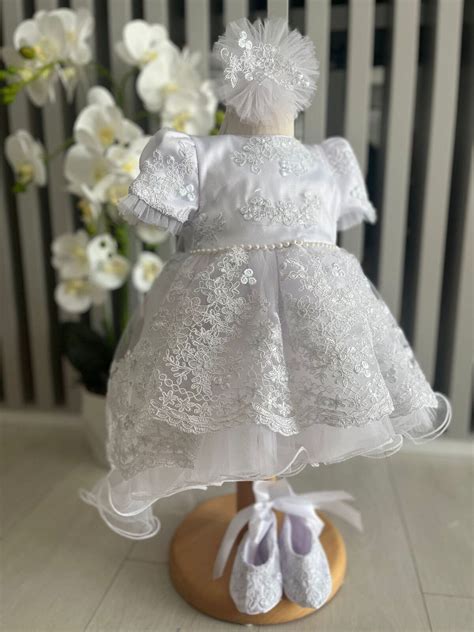 Set de botez complet pentru fetiță, incluzând rochiță, botosei și bentita.