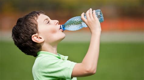Imagine cu un copil care bea apă dintr-o sticlă