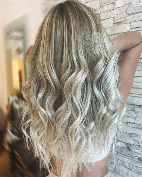 Femeie cu păr blond auriu, zâmbind, în lumina soarelui.