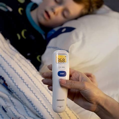 Imagine cu un părinte aplicând o compresă rece pe fruntea unui bebeluș