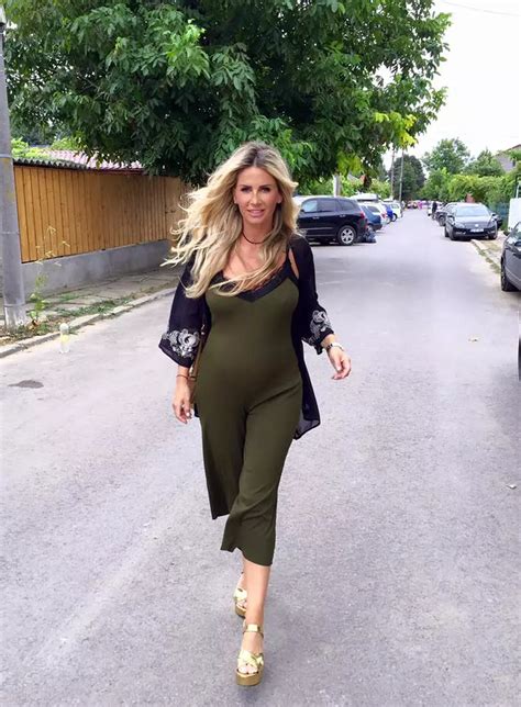 Andreea Bănică zâmbind, cu mâna pe abdomen, sugerând sarcina