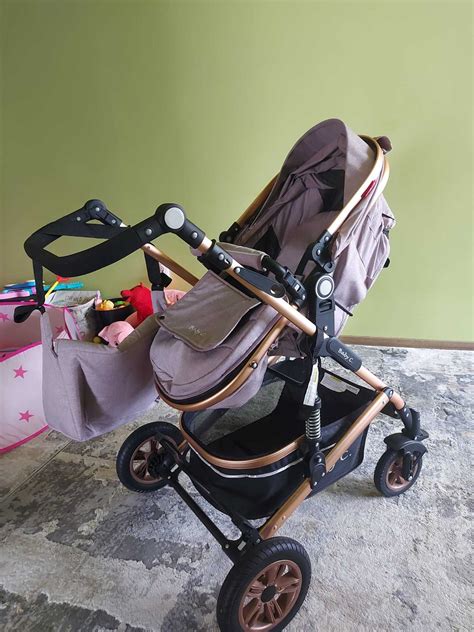 Ilustrație cu o scoică auto omologată pentru nou-născuți, prezentând sistemul de prindere și protecțiile laterale.