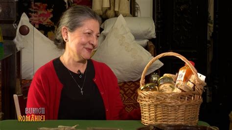 O bunică zâmbind cald, înconjurată de flori