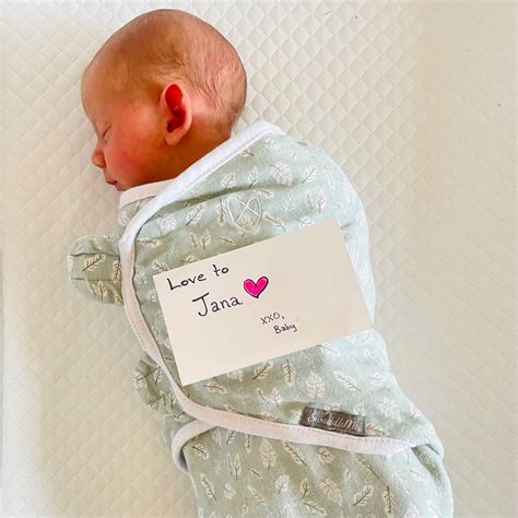 Fotografie cu o mamă care își ține bebelușul în brațe, într-o manieră protectoare și iubitoare.