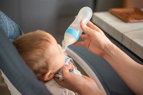 Bebeluș fericit care este hrănit cu biberonul