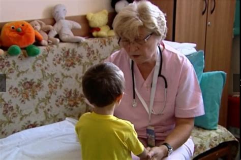 medic reumatolog pediatru examinând un copil