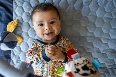 Fotografie cu un bebeluș atent la o jucărie colorată