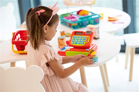 Copil care apasă o jucărie cu ventuză pe o masă