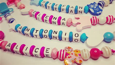 diverse modele de lantisoare pentru suzeta atasate de hainele unui bebelus