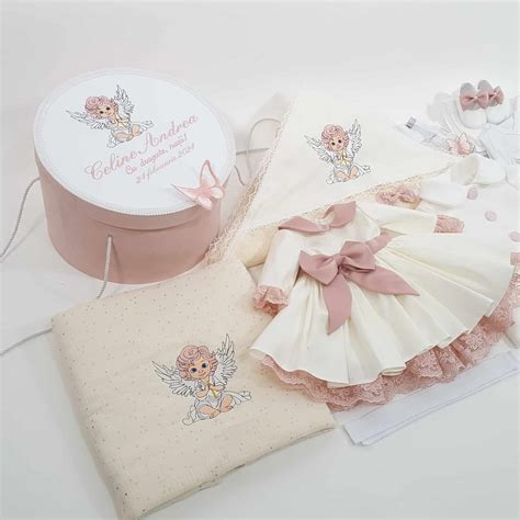 Exemplu de trusou pentru botez, cu elemente asortate: rochiță, bonetă, botoșei, lumânare, cutiuță mir.