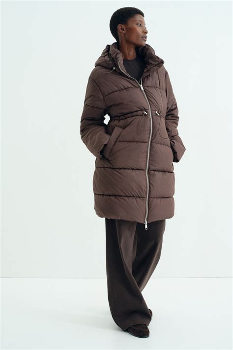 Ilustrație comparativă între o geacă obișnuită cu o mărime mai mare și o geacă specială pentru gravide, evidențiind diferențele de croială și adaptabilitate.