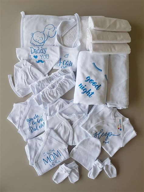 O colecție de articole esențiale pentru nou-născut, aranjate ordonat: pătuț, hăinuțe, biberoane, produse de igienă.