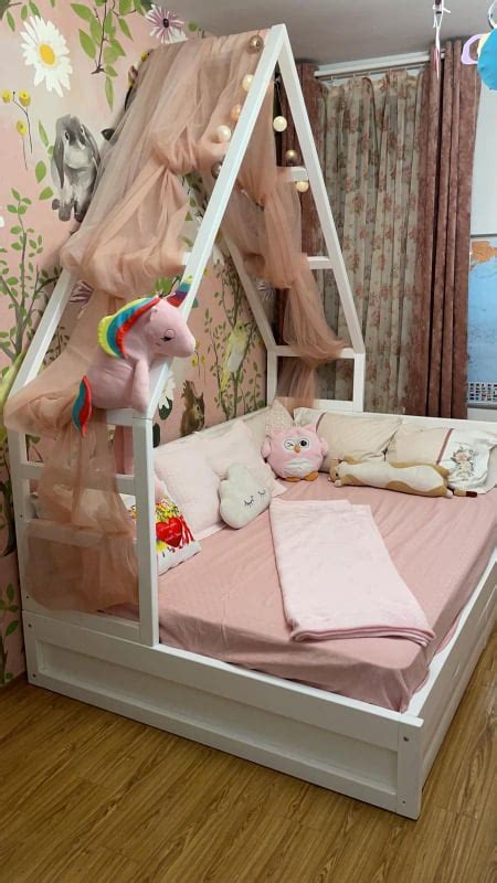 Copil dormind confortabil într-un pat pentru copii cu baldachin