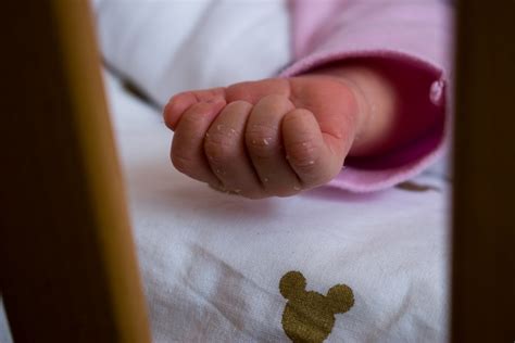 Bebeluș de 3 luni care își examinează mânuțele