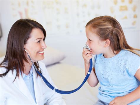 Fotografie cu un copil zâmbitor interacționând cu un medic pediatru