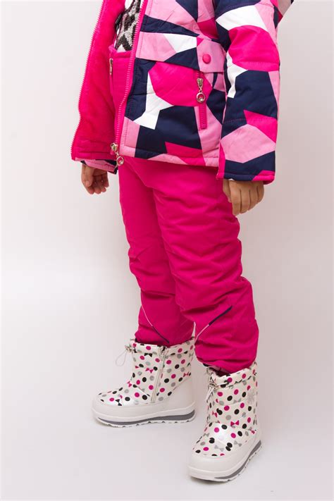 Copertă imagine: un bebeluș fericit într-un combinezon roz, jucându-se în zăpadă