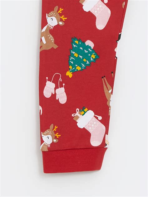 Un set de haine pentru bebeluși cu tematică de Crăciun, incluzând body, pantaloni și căciulă.