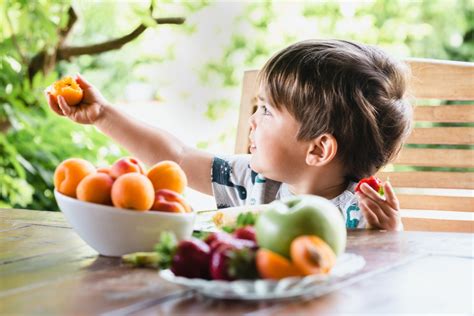 copil fericit mâncând fructe