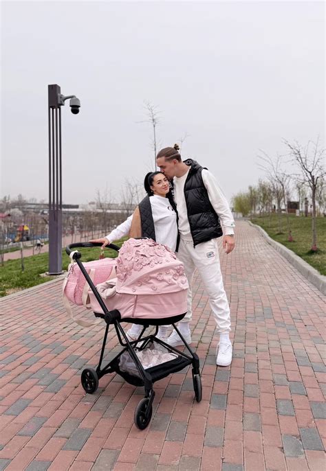 Familie bucurandu-se de o plimbare in parc cu un carucior 2 in 1