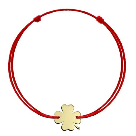 Fotografie cu o brățară din aur cu șnur roșu, potrivită pentru bebeluși, cu un pandantiv delicat.