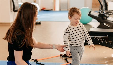 copil făcând kinetoterapie pentru a-și îndrepta picioarele