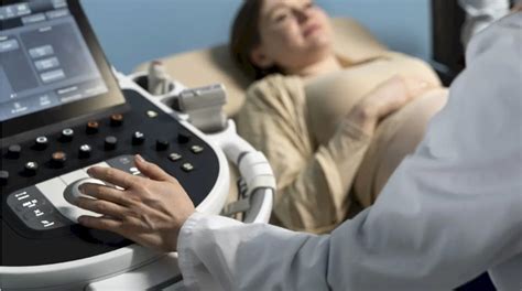 Medic ginecolog examinând un sân al pacientei în timpul consultației.