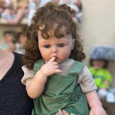 Close-up pe fața unei păpuși Llorens, evidențiind detaliile realiste ale ochilor și pielii