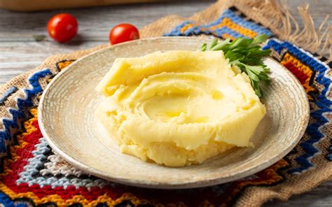 Ilustrație cu bebeluș vesel care mănâncă piure de cartofi dulci dintr-un recipient special.