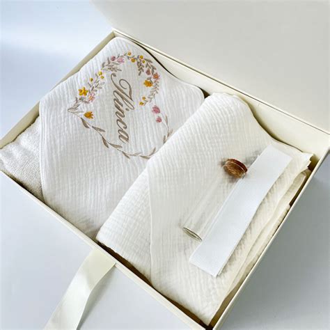 Exemplu de trusou de botez personalizat cu broderie cu numele și data botezului.