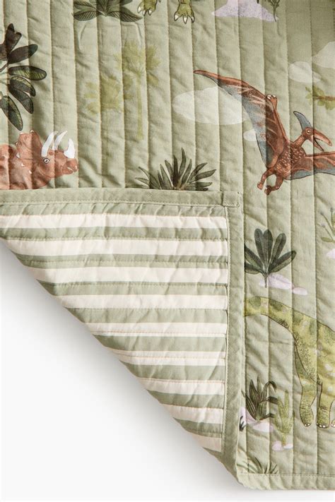 O păturică matlasată cu dungi discrete, prezentând un design modern și elegant