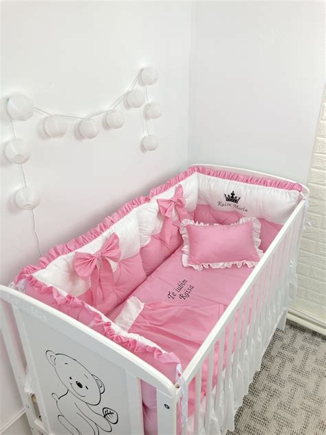 Exemplu de pătuț personalizat cu numele copilului și o lampă de veghe tematică.