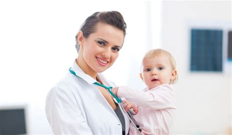 Fotografie a unui medic pediatru examinând un copil într-un cabinet modern.