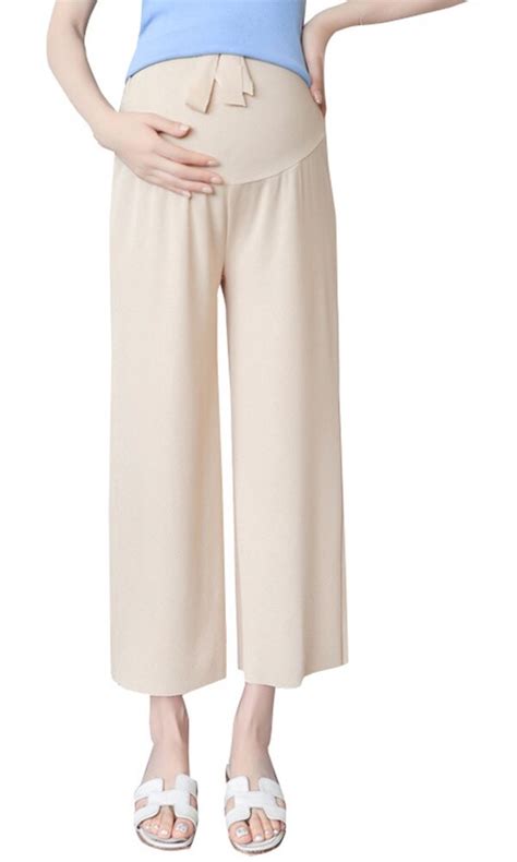 Ilustrație cu o femeie însărcinată purtând pantaloni medicali de maternitate, subliniind banda elastică adaptabilă.