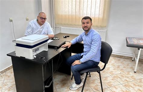 Fotografie a Dr. Oana Cristian în cabinetul medical, interacționând cu un copil sau părinte.