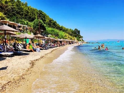 Plajă cu nisip fin, șezlonguri și umbrele la malul mării