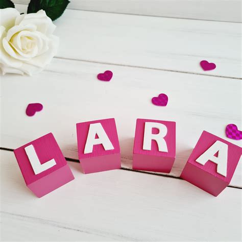 Ilustrație cu diverse litere 3D personalizate, cu nume de bebeluși sau inițiale.