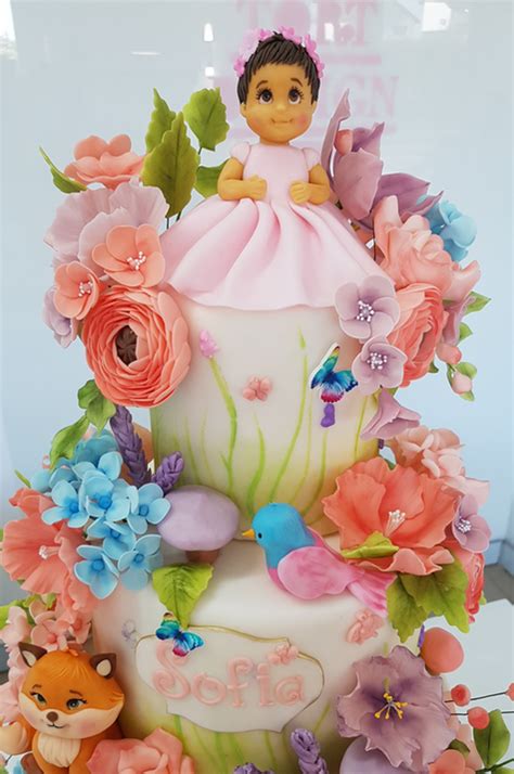 Ilustrație cu un tort de botez roz, decorat cu figurine de prințesă și flori