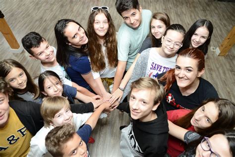 Ilustrație a unui grup de copii zâmbitori la o activitate școlară în limba germană.