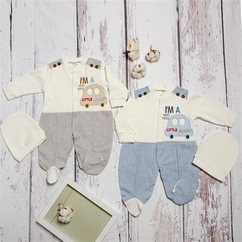 O varietate de haine pentru nou-născuți, inclusiv salopete, body-uri și rochii, în culori pastelate și țesături moi.