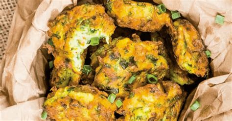 Un platou cu chifteluțe de pui cu dovlecel, frumos aranjate, alături de sosuri diverse și o salată verde.