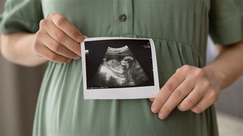 Femeie însărcinată cu burtica pictată cu motive florale